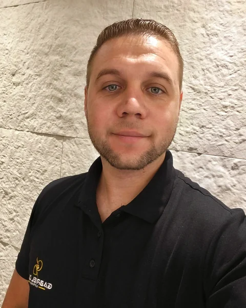 Gabriel Dias, eletricista, vestindo uma camisa polo preta.