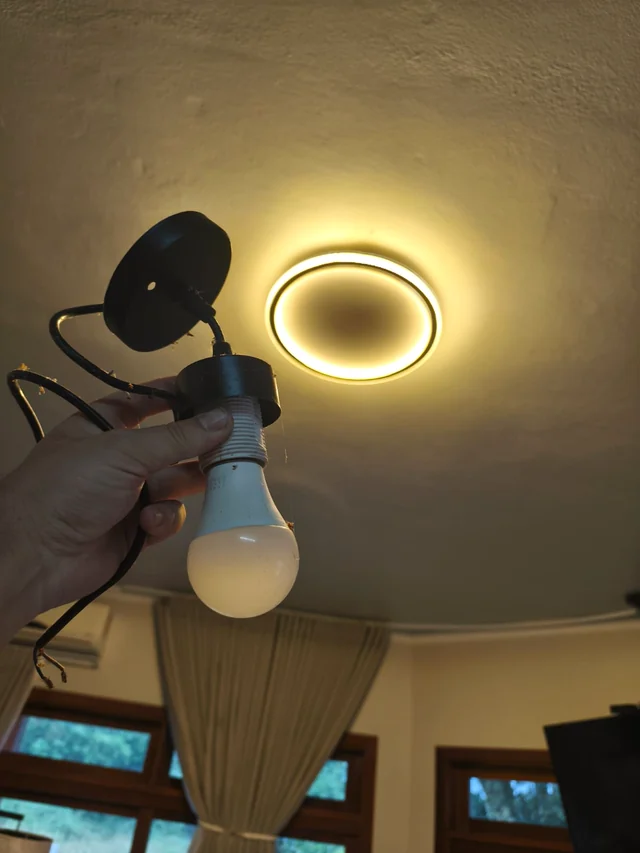 Registro da troca de uma luminária, com a peça anterior em primeiro plano.